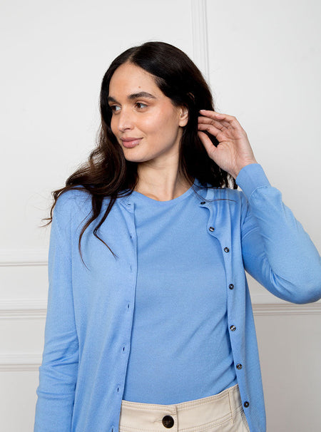 Woman wearing cornflower blue long sleeved cardigan knit top in premium and luxury sea island cotton. Paired with matching short sleeve knit top.